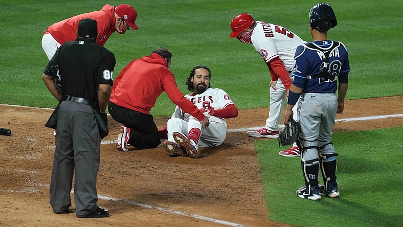 May 3, 2021; Anaheim, California, USA;  Los Angeles Angels third baseman Anthony Rendon (6) is attended by an athletic trainer after suffering an injury in the eighth inning as manager Joe Maddon (left) and third base coach Brian Buttterfield watch against the Tampa Bay Rays at Angel Stadium. Mandatory Credit: Kirby Lee-USA TODAY Sports