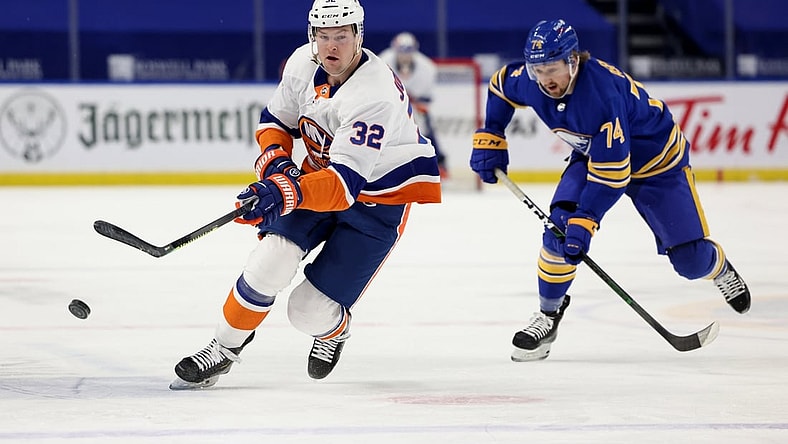 May 4, 2021; Buffalo, New York, USA;  New York Islanders left wing Ross Johnston (32) shoots the puck up ice as Buffalo Sabres center Rasmus Asplund (74) tries to defend during the first period at KeyBank Center. Mandatory Credit: Timothy T. Ludwig-USA TODAY Sports