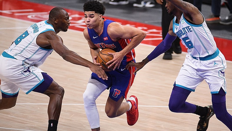 May 4, 2021; Detroit, Michigan, USA; Detroit Pistons guard Killian Hayes (7) drives to the basket as Charlotte Hornets center Bismack Biyombo (8) and forward Jalen McDaniels (6) defend during the second quarter at Little Caesars Arena. Mandatory Credit: Tim Fuller-USA TODAY Sports