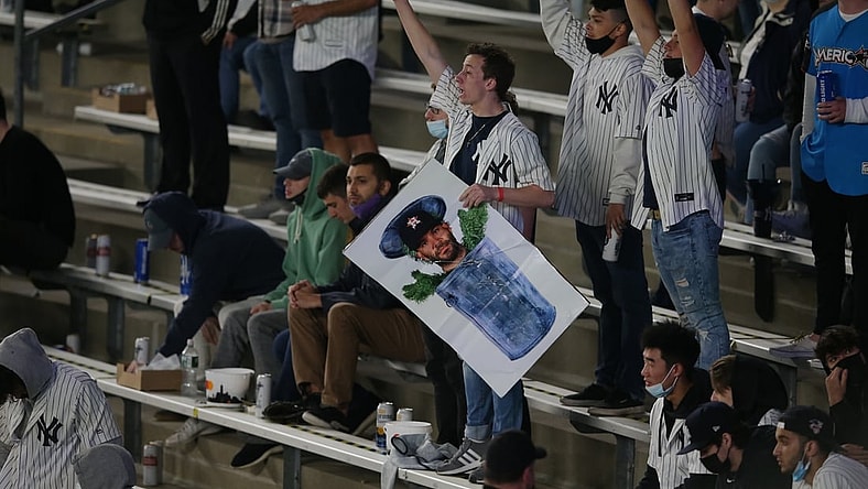 May 4, 2021; Bronx, New York, USA; A New York Yankees fan holding a picture of Houston Astros second baseman Jose Altuve (27) in a trash can reacts during the fifth inning at Yankee Stadium. Mandatory Credit: Brad Penner-USA TODAY Sports