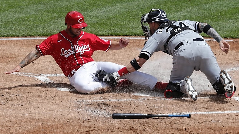 May 5, 2021; Cincinnati, Ohio, USA; Cincinnati Reds center fielder Nick Senzel (left) is tagged out at home by Chicago White Sox catcher Yasmani Grandal (24) during the first inning at Great American Ball Park. Mandatory Credit: David Kohl-USA TODAY Sports