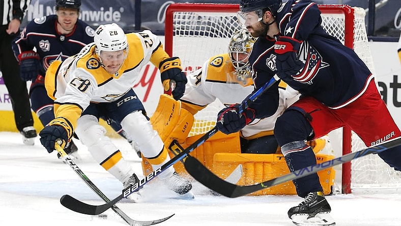 May 5, 2021; Columbus, Ohio, USA; Columbus Blue Jackets right wing Oliver Bjorkstrand (28) passes the puck as Nashville Predators right wing Eeli Tolvanen (28) reaches for the steal during the first period at Nationwide Arena. Mandatory Credit: Russell LaBounty-USA TODAY Sports
