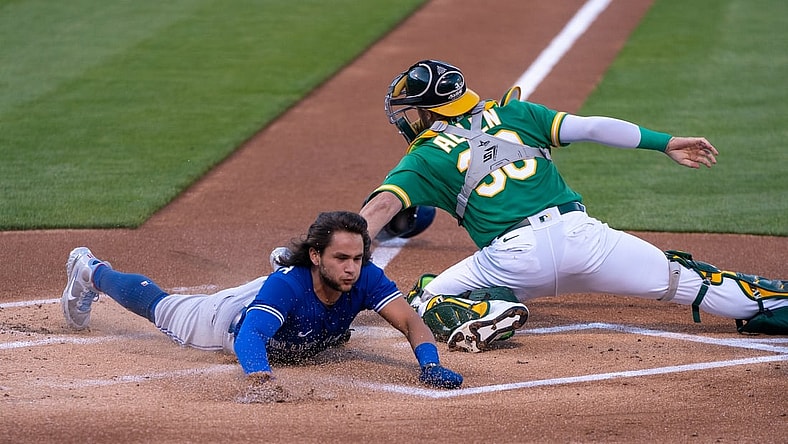 May 5, 2021; Oakland, California, USA; Toronto Blue Jays shortstop Bo Bichette (11) reaches home against Oakland Athletics catcher Austin Allen (30) during the first inning at RingCentral Coliseum. Mandatory Credit: Neville E. Guard-USA TODAY Sports