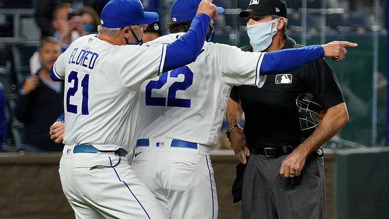 May 5, 2021; Kansas City, Missouri, USA; Kansas City Royals pitching coach Cal Eldred (21) and manager Mike Matheny (22) argue with umpire Angel Hernandez (5) shortly before being ejected in the sixth inning against the Cleveland Indians at Kauffman Stadium. Mandatory Credit: Denny Medley-USA TODAY Sports