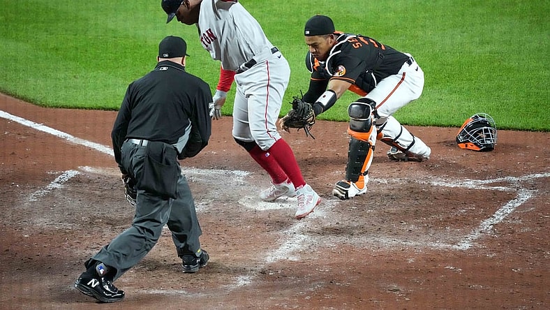 May 7, 2021; Baltimore, Maryland, USA; Boston Red Sox third baseman Rafael Devers (C) scores a run on a single by catcher Christian Vasquez (not pictured) ahead of the tag by Baltimore Orioles catcher Pedro Severino (R) during the eighth inning at Oriole Park at Camden Yards. Mandatory Credit: Mitch Stringer-USA TODAY Sports