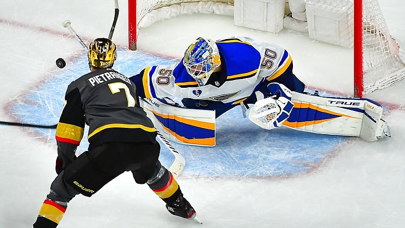 May 7, 2021; Las Vegas, Nevada, USA; St. Louis Blues goaltender Jordan Binnington (50) deflects the puck away from Vegas Golden Knights defenseman Alex Pietrangelo (7) during an overtime period at T-Mobile Arena. Mandatory Credit: Stephen R. Sylvanie-USA TODAY Sports
