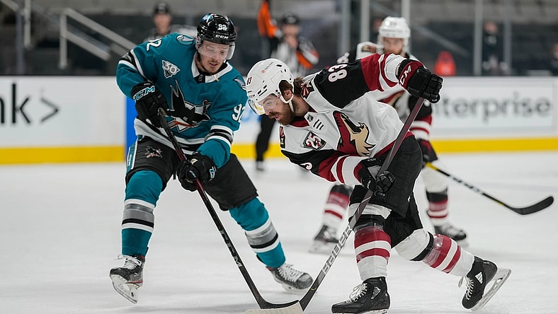 May 7, 2021; San Jose, California, USA; Arizona Coyotes right wing Conor Garland (83) and San Jose Sharks left wing Rudolfs Balcers (92) battle for control of the puck during the second period at SAP Center at San Jose. Mandatory Credit: Stan Szeto-USA TODAY Sports