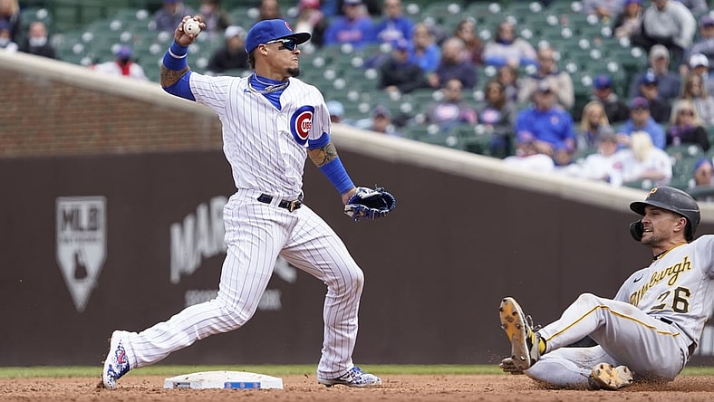 May 8, 2021; Chicago, Illinois, USA; Chicago Cubs shortstop Javier Baez (9) forces out Pittsburgh Pirates second baseman Adam Frazier (26) at second base during the third inning at Wrigley Field. Mandatory Credit: David Banks-USA TODAY Sports