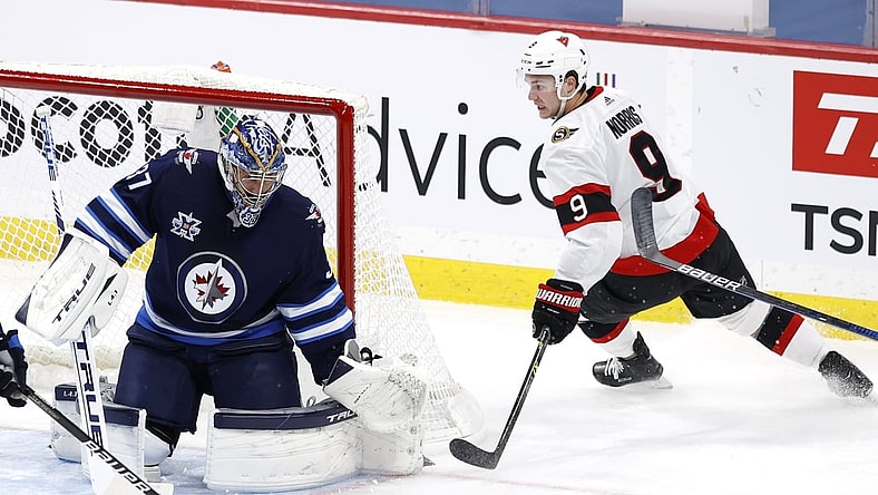 May 8, 2021; Winnipeg, Manitoba, CAN;  Winnipeg Jets goaltender Connor Hellebuyck (37) blocks a shot by Ottawa Senators center Josh Norris (9) in the first period at Bell MTS Place. Mandatory Credit: James Carey Lauder-USA TODAY Sports