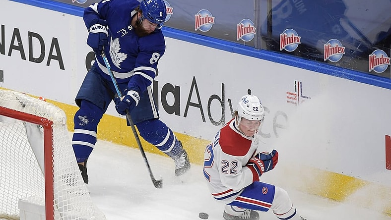 May 8, 2021; Toronto, Ontario, CAN; Toronto Maple Leafs defenseman Jake Muzzin (8) shoots the puck past Montreal Canadiens forward Cole Caulfield (22) in the first period at Scotiabank Arena. Mandatory Credit: Dan Hamilton-USA TODAY Sports