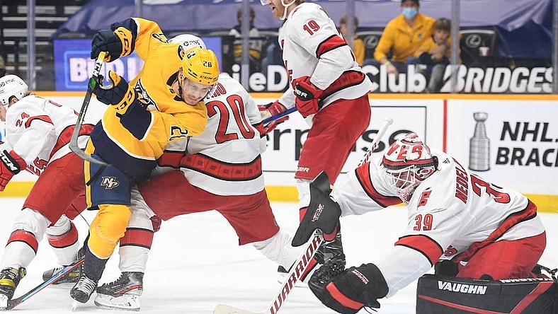 May 8, 2021; Nashville, Tennessee, USA; Nashville Predators right wing Eeli Tolvanen (28) tries to get around Carolina Hurricanes right wing Sebastian Aho (20) before the puck is covered by Carolina Hurricanes goaltender Alex Nedeljkovic (39) during the first period at Bridgestone Arena. Mandatory Credit: Christopher Hanewinckel-USA TODAY Sports