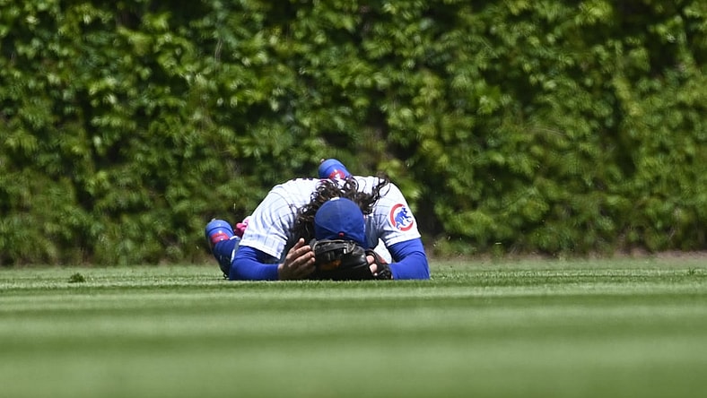 May 9, 2021; Chicago, Illinois, USA;  Chicago Cubs center fielder Jake Marisnick (6) lays on the ground after Pittsburgh Pirates shortstop Wilmer Difo (15)  hit a two RBI single during the first inning at Wrigley Field. Mandatory Credit: Matt Marton-USA TODAY Sports