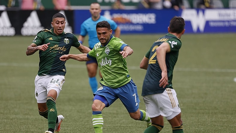 May 9, 2021; Portland, Oregon, USA; Seattle Sounders midfielder Cristian Roldan (7) takes a shot on goal against Portland Timbers midfielder Marvin Lor a (44) during the first half at Providence Park. Mandatory Credit: Soobum Im-USA TODAY Sports