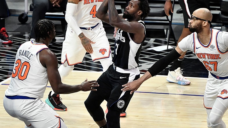 May 9, 2021; Los Angeles, California, USA; LA Clippers guard Patrick Beverley (21) drives to the basket between New York Knicks forward Julius Randle (30), guard Derrick Rose (4) and center Taj Gibson (67) during the first quarter at Staples Center. Mandatory Credit: Robert Hanashiro-USA TODAY Sports