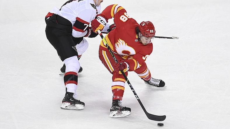 May 9, 2021; Calgary, Alberta, CAN; Calgary Flames forward Andrew Mangiapane (88) battles for the puck with Ottawa Senators forward Brady Tkachuk (7) during the second period at Scotiabank Saddledome. Mandatory Credit: Candice Ward-USA TODAY Sports