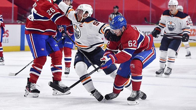 May 10, 2021; Montreal, Quebec, CAN; Edmonton Oilers forward Connor McDavid (97) attempts to go between Montreal Canadiens defenseman Jeff Petry (26) and teammate forward Artturi Lehkonen (62) during the first period at the Bell Centre. Mandatory Credit: Eric Bolte-USA TODAY Sports