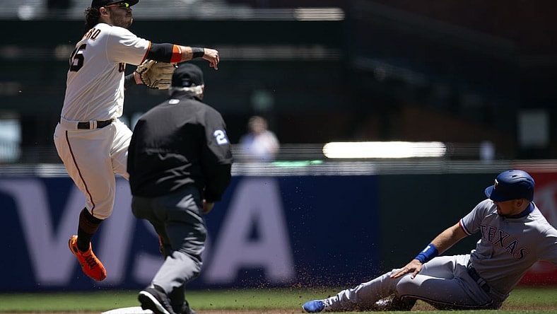 May 11, 2021; San Francisco, California, USA; San Francisco Giants shortstop Brandon Crawford (35) throws over Texas Rangers first baseman Nate Lowe too late to double up Joey Gallo at first base during the first inning at Oracle Park. Texas Rangers shortstop Isiah Kiner-Falefa scored from third on the play. Mandatory Credit: D. Ross Cameron-USA TODAY Sports
