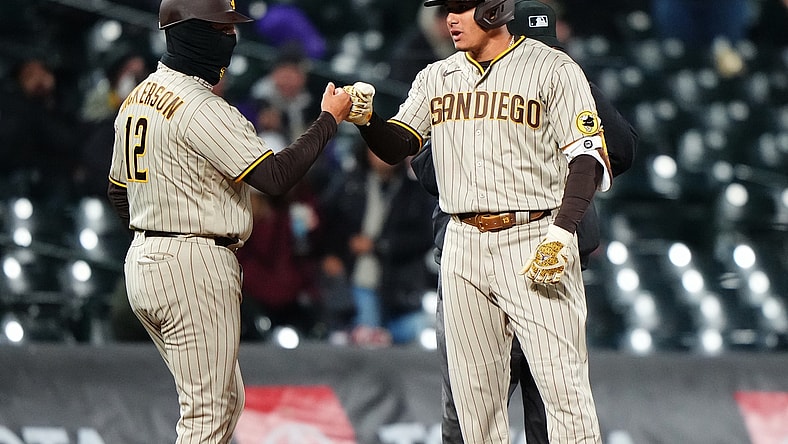 May 11, 2021; Denver, Colorado, USA; San Diego Padres third baseman Manny Machado (13) celebrates his three run triple with third base coach Bobby Dickerson (12) in the sixth inning against the Colorado Rockies at Coors Field. Mandatory Credit: Ron Chenoy-USA TODAY Sports