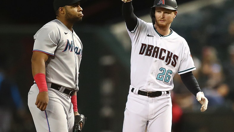 May 11, 2021; Phoenix, Arizona, USA; Miami Marlins first baseman Jesus Aguilar (left) reacts as Arizona Diamondbacks outfielder Pavin Smith celebrates after hitting an RBI single in the fifth inning at Chase Field. Mandatory Credit: Mark J. Rebilas-USA TODAY Sports