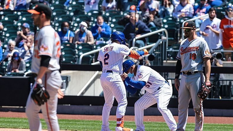 May 12, 2021; New York City, New York, USA; New York Mets first baseman Dominic Smith (2) reacts with first base coach Tony Tarasco (51) after hitting an RBI single against Baltimore Orioles starting pitcher Matt Harvey (32) during the fifth inning at Citi Field. Mandatory Credit: Vincent Carchietta-USA TODAY Sports