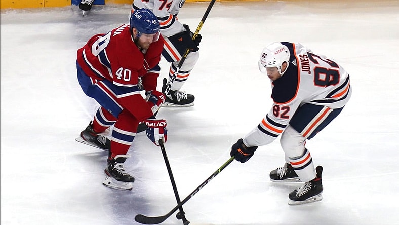 May 12, 2021; Montreal, Quebec, CAN; Montreal Canadiens right wing Joel Armia (40) and Edmonton Oilers defenseman Caleb Jones (82) battle for the puck during the second period at Bell Centre. Mandatory Credit: Jean-Yves Ahern-USA TODAY Sports