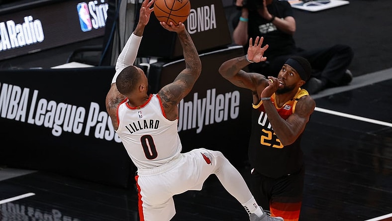 May 12, 2021; Salt Lake City, Utah, USA; Portland Trail Blazers guard Damian Lillard (0) shoots a fade jump shot away from Utah Jazz forward Royce O'Neale (23) during the second quarter at Vivint Arena. Mandatory Credit: Chris Nicoll-USA TODAY Sports