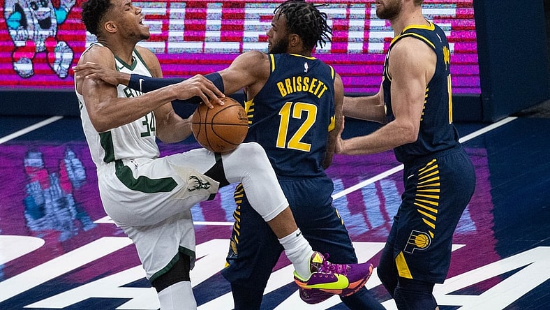 May 13, 2021; Indianapolis, Indiana, USA; Milwaukee Bucks forward Giannis Antetokounmpo (34) is fouled by Indiana Pacers forward Oshae Brissett (12) in the third quarter at Bankers Life Fieldhouse. Mandatory Credit: Trevor Ruszkowski-USA TODAY Sports