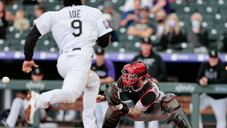 May 13, 2021; Denver, Colorado, USA; Cincinnati Reds catcher Tucker Barnhart (16) fields a throw as Colorado Rockies first baseman Connor Joe (9) runs towards home plate during the first inning at Coors Field. Mandatory Credit: Isaiah J. Downing-USA TODAY Sports