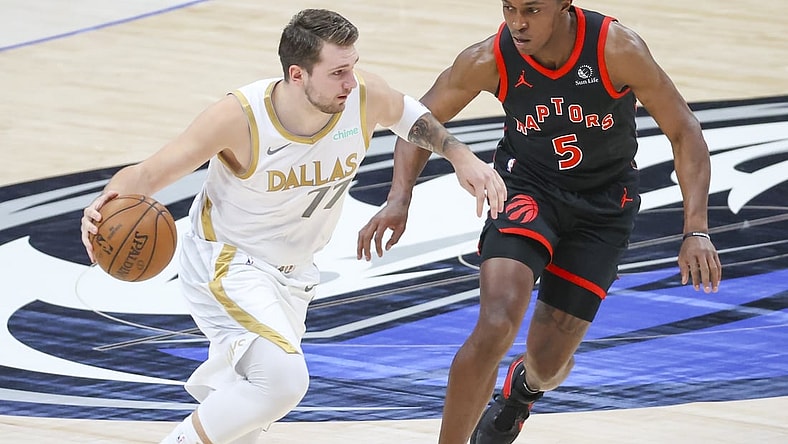 May 14, 2021; Dallas, Texas, USA;  Dallas Mavericks guard Luka Doncic (77) dribbles the ball as Toronto Raptors forward Stanley Johnson (5) defends during the first quarter at American Airlines Center. Mandatory Credit: Kevin Jairaj-USA TODAY Sports