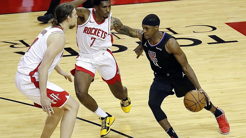 May 14, 2021; Houston, Texas, USA; LA Clippers guard Rajon Rondo (4) drives against Houston Rockets guard Armoni Brooks (7) and forward Kelly Olynyk (41) during the second quarter at Toyota Center. Mandatory Credit:  Bob Levey/Pool Photo-USA TODAY Sports