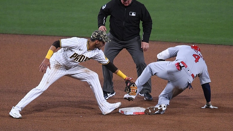 May 14, 2021; San Diego, California, USA; St. Louis Cardinals catcher Yadier Molina (4) slides into second base ahead of the tag by San Diego Padres second baseman Tucupita Marcano (L) after hitting a double during the fourth inning as umpire Greg Gibson (C) looks on at Petco Park. Mandatory Credit: Orlando Ramirez-USA TODAY Sports