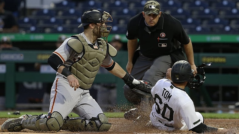 May 15, 2021; Pittsburgh, Pennsylvania, USA;  San Francisco Giants catcher Curt Casali (2) tags Pittsburgh Pirates pinch hitter Ka'ai Tom (60) out at home attempting to score as umpire Mark Ripperger (90)looks on during the fifth inning at PNC Park. Mandatory Credit: Charles LeClaire-USA TODAY Sports