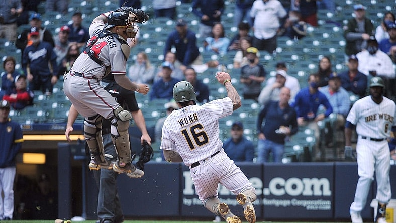 May 16, 2021; Milwaukee, Wisconsin, USA;  Milwaukee Brewers second baseman Kolten Wong (16) scores a run as the throw is high and no tag was made by Atlanta Braves catcher William Contreras (24) in the fourth inning at American Family Field. Mandatory Credit: Michael McLoone-USA TODAY Sports