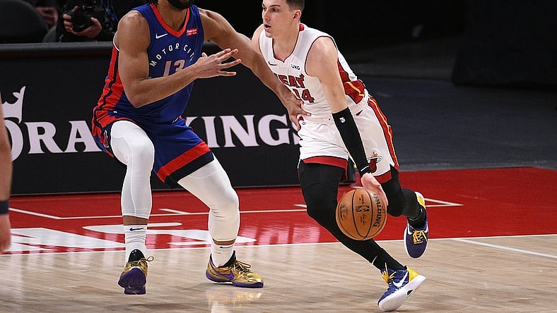 May 16, 2021; Detroit, Michigan, USA; Miami Heat guard Tyler Herro (14) drives to the basket as Detroit Pistons center Jahlil Okafor (13) defends during the first quarter at Little Caesars Arena. Mandatory Credit: Tim Fuller-USA TODAY Sports
