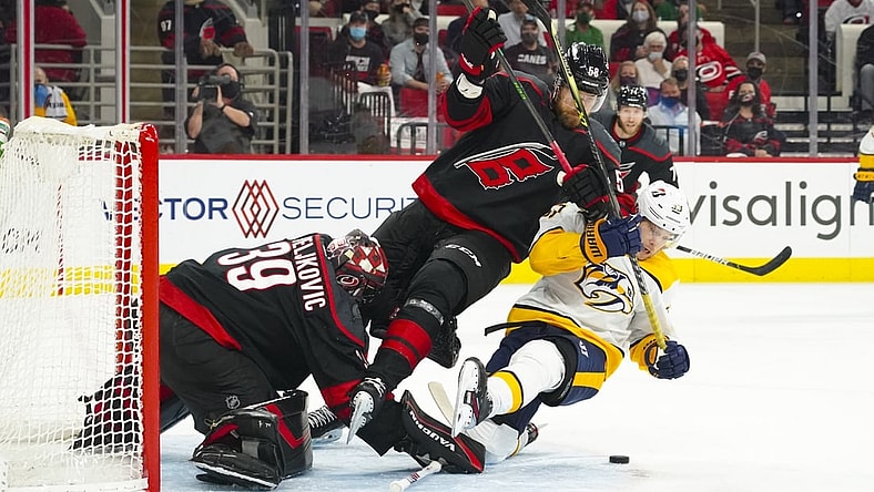 May 17, 2021; Raleigh, North Carolina, USA; Carolina Hurricanes goaltender Alex Nedeljkovic (39) and defenseman Jani Hakanpaa (58) battle Nashville Predators right wing Viktor Arvidsson (33) for the puck during the first period  in game one of the first round of the 2021 Stanley Cup Playoffs at PNC Arena. Mandatory Credit: James Guillory-USA TODAY Sports