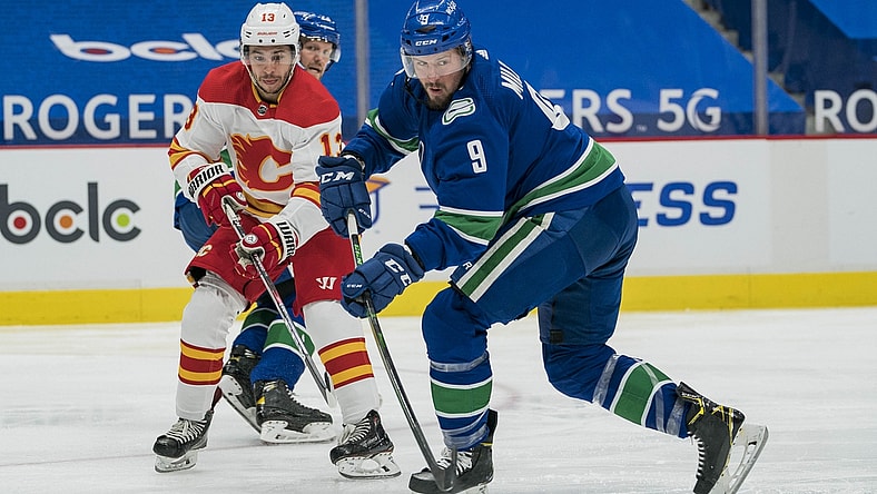 May 18, 2021; Vancouver, British Columbia, CAN; Calgary Flames forward Johnny Gaudreau (13) checks Vancouver Canucks forward J.T. Miller (9) in the second period at Rogers Arena. Mandatory Credit: Bob Frid-USA TODAY Sports