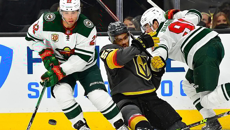 May 18, 2021; Las Vegas, Nevada, USA; Vegas Golden Knights right wing Keegan Kolesar (55) is hit by Minnesota Wild center Marcus Johansson (90) as Minnesota Wild left wing Kevin Fiala (22) chips the puck away during the second period of game two of the first round of the 2021 Stanley Cup Playoffs at T-Mobile Arena. Mandatory Credit: Stephen R. Sylvanie-USA TODAY Sports