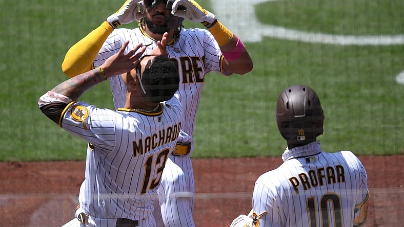 May 19, 2021; San Diego, California, USA; San Diego Padres shortstop Fernando Tatis Jr. (top) celebrates with  third baseman Manny Machado (13) after hitting a home run against the Colorado Rockies during the fourth inning at Petco Park. Mandatory Credit: Orlando Ramirez-USA TODAY Sports