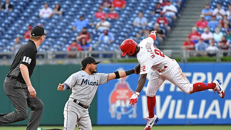 May 19, 2021; Philadelphia, Pennsylvania, USA;  Miami Marlins shortstop Miguel Rojas (19) tags out Philadelphia Phillies center fielder Andrew McCutchen (22) during the first inning at Citizens Bank Park. Mandatory Credit: Eric Hartline-USA TODAY Sports