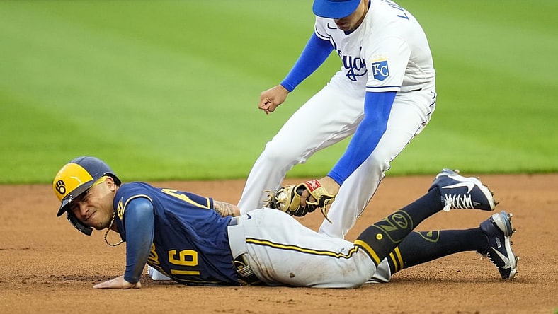 May 19, 2021; Kansas City, Missouri, USA; Milwaukee Brewers second baseman Kolten Wong (16) slides back to second base ahead of the tag by Kansas City Royals shortstop Nicky Lopez (8) during the first inning at Kauffman Stadium. Mandatory Credit: Jay Biggerstaff-USA TODAY Sports