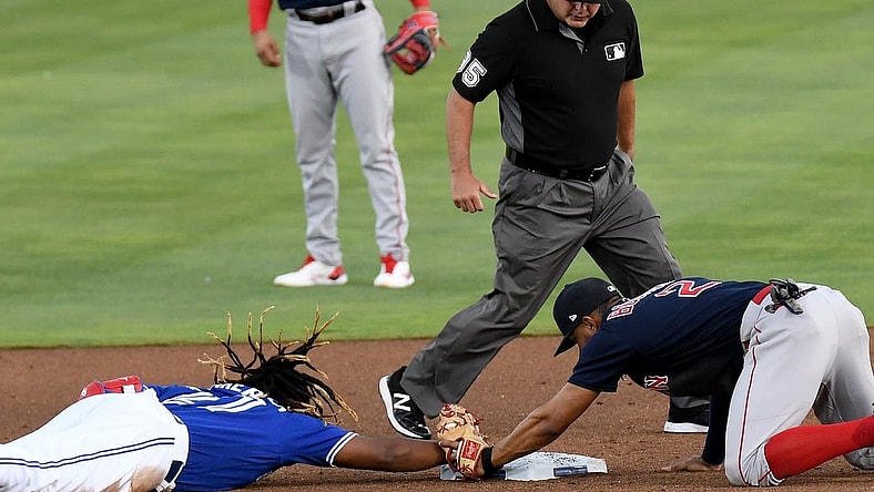 May 19, 2021; Dunedin, Florida, CAN; Toronto Blue Jays infielder Vladimir Guerrero Jr. (27) dives back to second base as Boston Red Sox infielder Xander Bogaerts (2) attempts a tag in the first inning  at TD Ballpark. Mandatory Credit: Jonathan Dyer-USA TODAY Sports