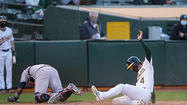 May 19, 2021; Oakland, California, USA;  Oakland Athletics third baseman Chad Pinder (4) slides home during the second inning against the Houston Astros at RingCentral Coliseum. Mandatory Credit: Stan Szeto-USA TODAY Sports
