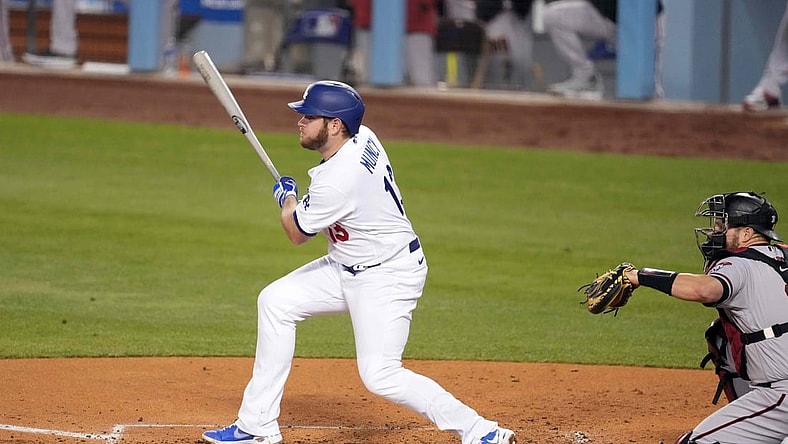 May 20, 2021; Los Angeles, California, USA; Los Angeles Dodgers second baseman Max Muncy (13) follows through on a single during the third inning as Arizona Diamondbacks catcher Stephen Vogt (21) watches  at Dodger Stadium. Mandatory Credit: Kirby Lee-USA TODAY Sports