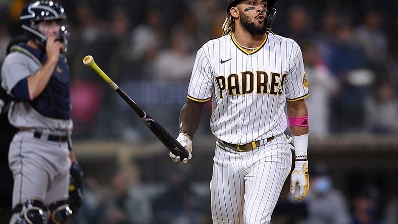May 21, 2021; San Diego, California, USA; San Diego Padres shortstop Fernando Tatis Jr. (right) tosses his bat after hitting a three-run home run during the second inning as Seattle Mariners catcher Tom Murphy (left) looks on at Petco Park. Mandatory Credit: Orlando Ramirez-USA TODAY Sports
