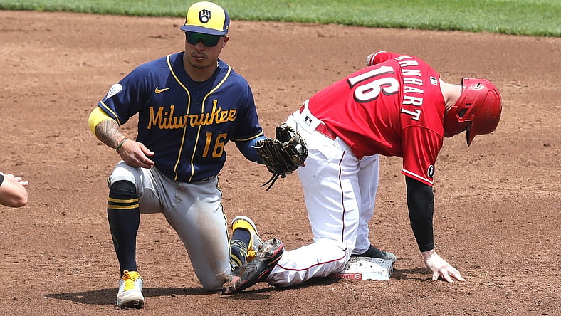May 23, 2021; Cincinnati, Ohio, USA; Cincinnati Reds catcher Tucker Barnhart (16) is safe at second against Milwaukee Brewers second baseman Kolten Wong (16) after a wild pitch during the second inning at Great American Ball Park. Mandatory Credit: David Kohl-USA TODAY Sports