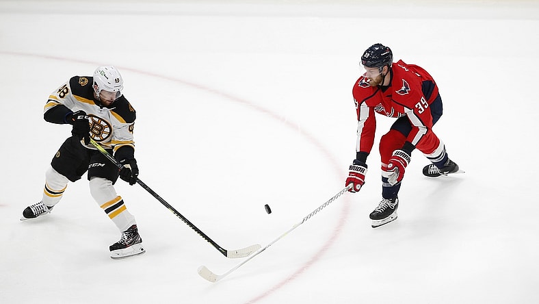 May 23, 2021; Washington, District of Columbia, USA; Boston Bruins defenseman Matt Grzelcyk (48) battles for the puck with Washington Capitals right wing Anthony Mantha (39) during the first period in game five of the first round of the 2021 Stanley Cup Playoffs at Capital One Arena. Mandatory Credit: Amber Searls-USA TODAY Sports