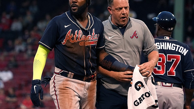 May 25, 2021; Boston, Massachusetts, USA; Atlanta Braves left fielder Marcell Ozuna (left) is assisted by a trainer after being injured against the Boston Red Sox during the third inning at Fenway Park. Mandatory Credit: David Butler II-USA TODAY Sports