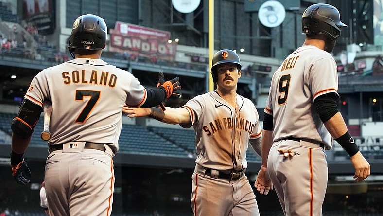 May 25, 2021; Phoenix, Arizona, USA; San Francisco Giants third baseman Evan Longoria (10) celebrates with shortstop Donovan Solano (7) and first baseman Brandon Belt (9) after scoring a run in the first inning against the Arizona Diamondbacks at Chase Field. Mandatory Credit: Rick Scuteri-USA TODAY Sports