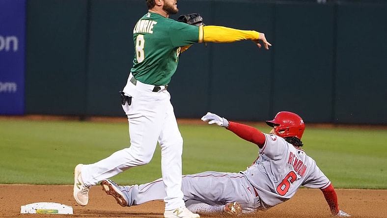 May 28, 2021; Oakland, California, USA; Oakland Athletics second baseman Jed Lowrie (8) turns a double play against Los Angeles Angels third baseman Anthony Rendon (6) during the sixth inning at RingCentral Coliseum. Mandatory Credit: Kelley L Cox-USA TODAY Sports