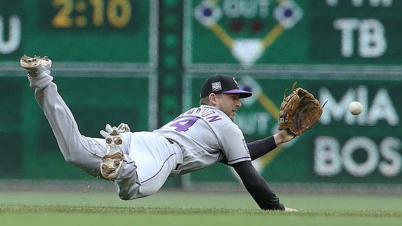 May 30, 2021; Pittsburgh, Pennsylvania, USA; Colorado Rockies second baseman Ryan McMahon (24) makes a diving stop on a ball hit by Pittsburgh Pirates third baseman Erik Gonzalez (not pictured) during the second inning at PNC Park. Mandatory Credit: Charles LeClaire-USA TODAY Sports